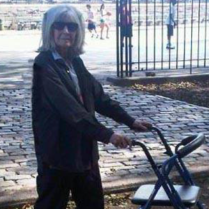 Bette Dewing looking at the camera and holding her rollator