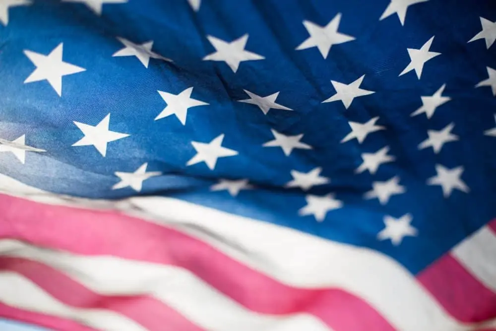 Close-up of the United States flag showing white stars on a blue field and red and white stripes, with the fabric slightly wrinkled and gently waving.