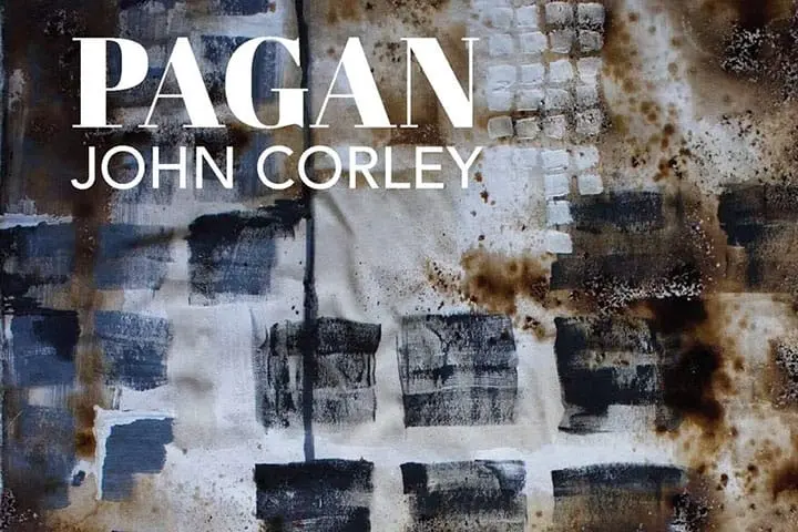 Abstract artwork with square patterns in dark blue, black, and white tones, with rust-colored stains. Overlaid large white text reads PAGAN and smaller text below reads JOHN CORLEY.