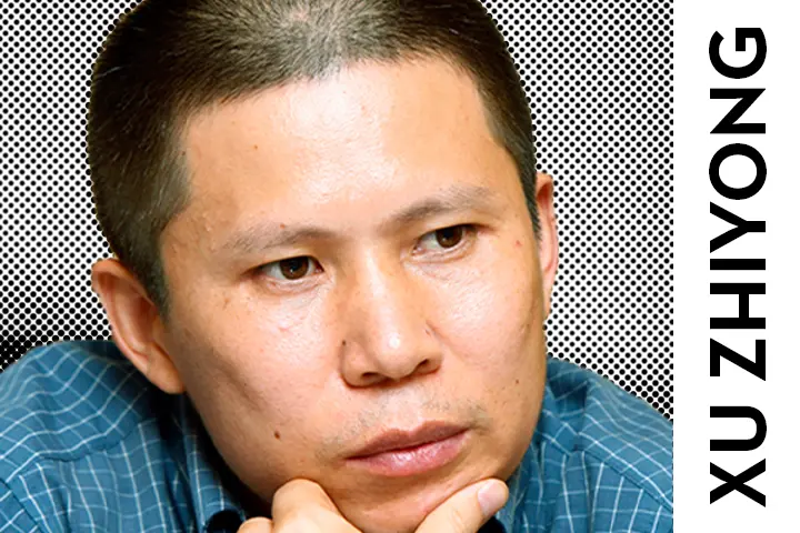 A person with short hair and a blue checkered shirt rests their chin on their hand. The background is patterned, and the text XU ZHIYONG is vertically displayed on the right side.