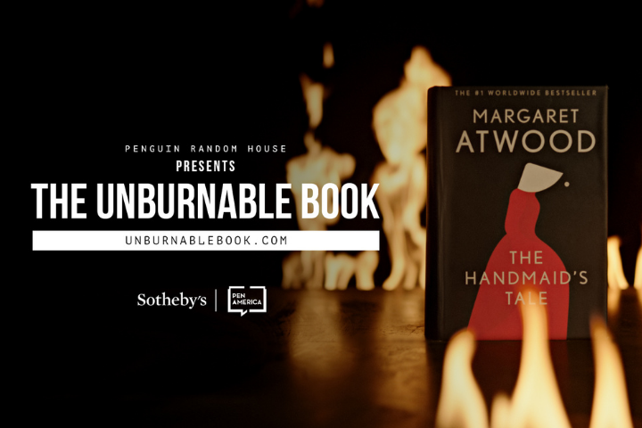 A copy of Margaret Atwood’s “The Handmaid’s Tale” stands upright with flames in the foreground. Text reads: “Penguin Random House presents The Unburnable Book. unburnablebook.com. Sotheby’s. PEN America.”.