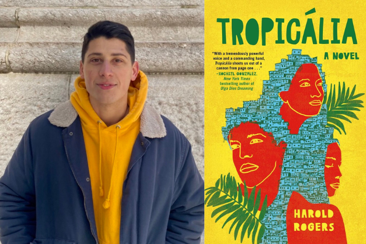 A man in a yellow hoodie and blue coat stands beside the book cover of Tropicália by Harold Rogers, which features illustrated faces among blue houses on a bright yellow background.