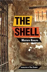 Book cover for The Shell by Mustafa Khalifa, translated by Paul Starkey. Reminiscent of Molly Crabapple’s evocative style, the design features a prison cell with barred windows and peeling walls, conveying a sense of confinement and hardship.