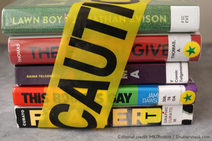 A stack of colorful library books wrapped with yellow caution tape, each featuring a green star sticker on its spine. The caution tape partially covers the titles, symbolizing the need for Book Ban Resources.