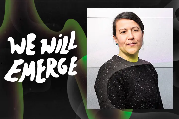 A woman with dark hair pulled back, wearing a black speckled sweater, stands before a light-colored wall. Next to her, bold white text reads We Will Emerge—an inspiring message for the voting 2020 election—on a dark background with green abstract shapes.
