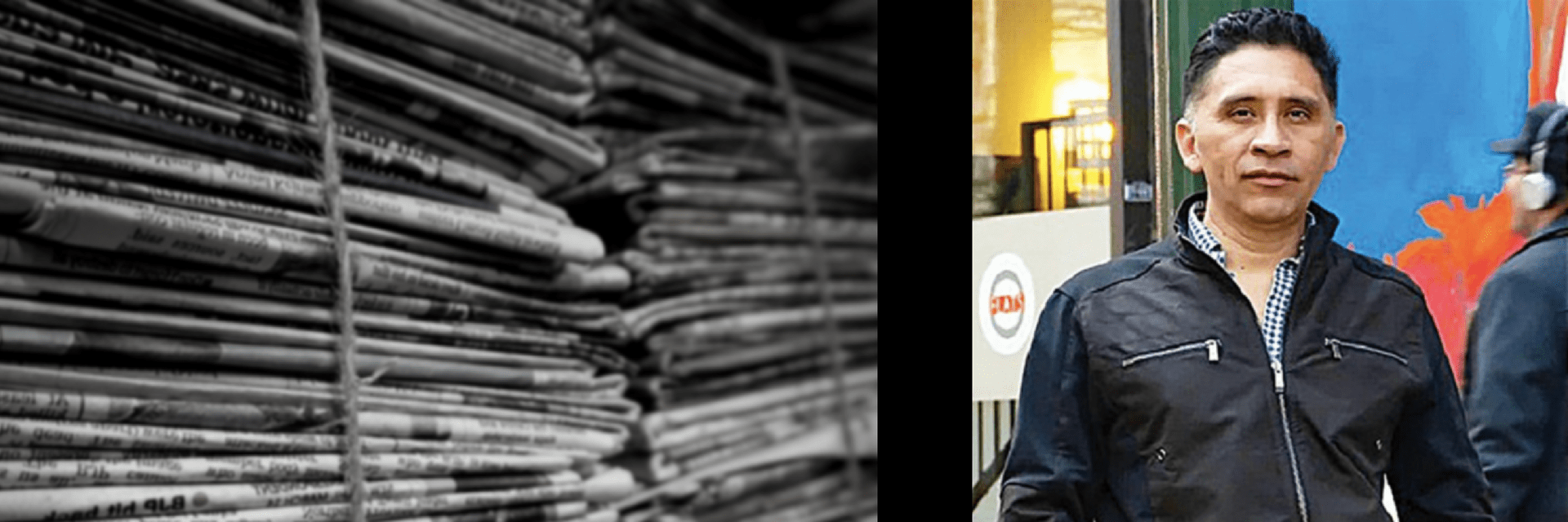 A stack of tied newspapers in black and white is shown on the left, while on the right, a man in a black jacket stands outside in front of a colorful mural and a glass door.