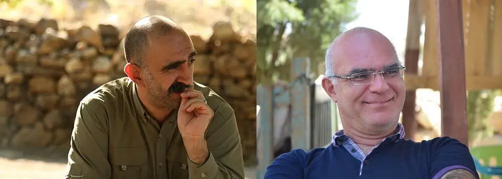 Two middle-aged men with shaved heads and mustaches are pictured side by side outdoors. The man on the left is thoughtful, resting his hand on his chin, while the man on the right is smiling and wearing glasses.