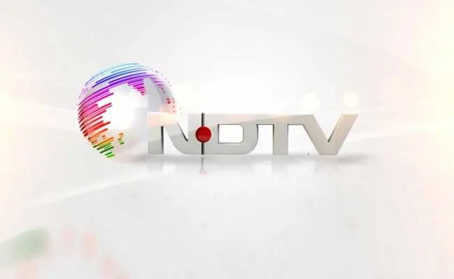 NDTV logo featuring a stylized globe with colorful lines on the left and the letters NDTV in silver on a light background, with a red dot between the N and D.