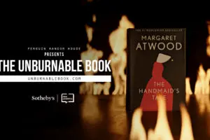 A copy of Margaret Atwood’s “The Handmaid’s Tale” stands upright amid flames, with the text The Unburnable Book and website, presented by Penguin Random House, displayed on the left.