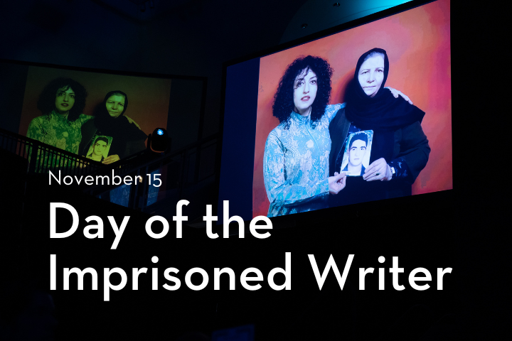 Two women holding a photo of a young man are displayed on a large screen. Text reads “November 15, Day of the Imprisoned Writer.” The scene appears to be at an indoor event or ceremony.