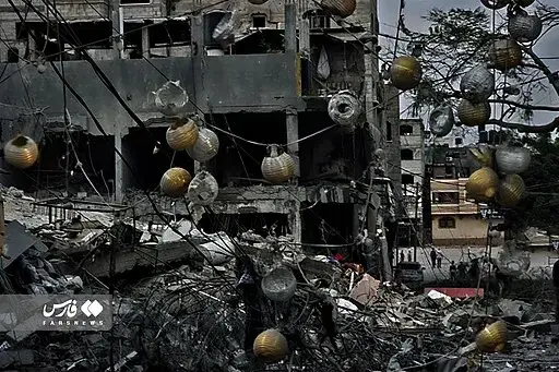 A destroyed building with rubble and debris in the foreground; yellow paper lanterns and wires are tangled among the wreckage, and the sky appears dark and overcast.