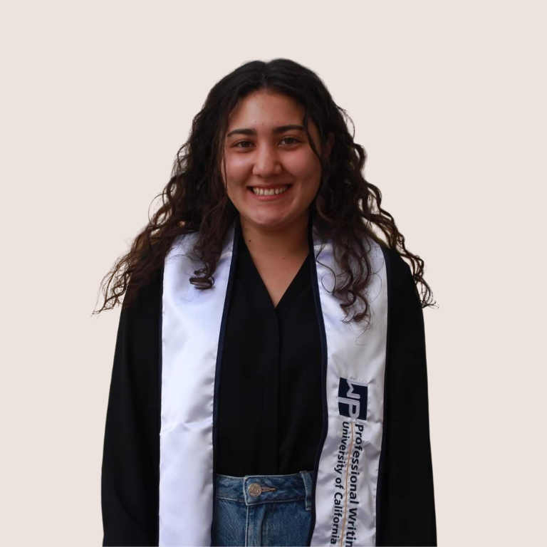 A young woman with long, curly hair smiles while wearing a graduation gown and a white stole that reads Professional Multicultural University of California on a plain background.
