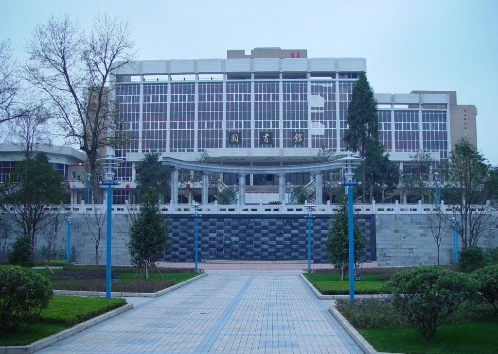 A large, modern building with a glass facade and Chinese characters above the entrance, surrounded by trees, shrubs, and a paved walkway—reflecting themes central to the Freedom to Write Index 2021.