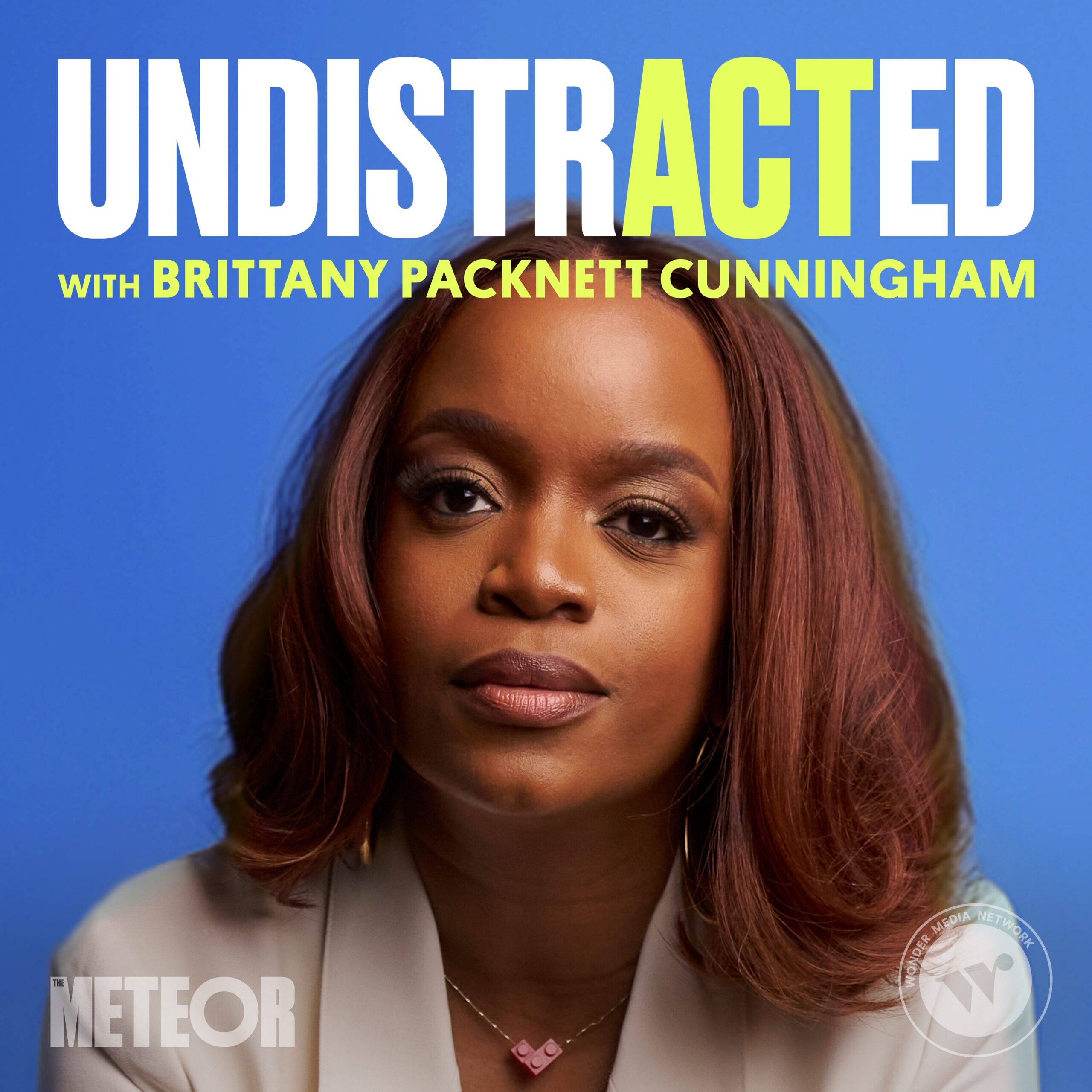 A woman with reddish-brown hair and a serious expression sits against a blue background. Text above her reads, UNDISTRACTED with Brittany Packnett Cunningham. The Meteor logo appears in the corner, highlighting Banned Books Week 2024.