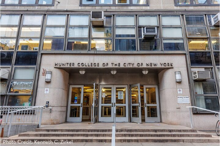 Front entrance of Hunter College of the City University of New York, featuring large windows, multiple double doors, and a concrete façade. A sign displays the colleges name above the entrance.