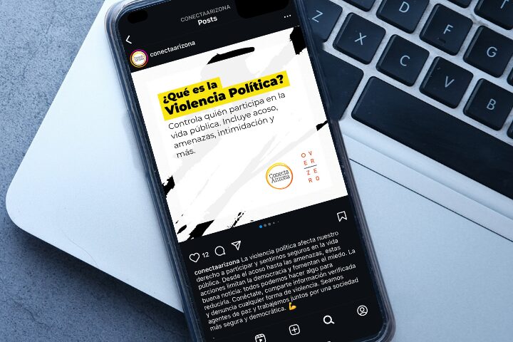 Smartphone displaying an Instagram post about Violencia Política, describing it as harassment, threats, intimidation in public life. The phone rests on a laptop keyboard.