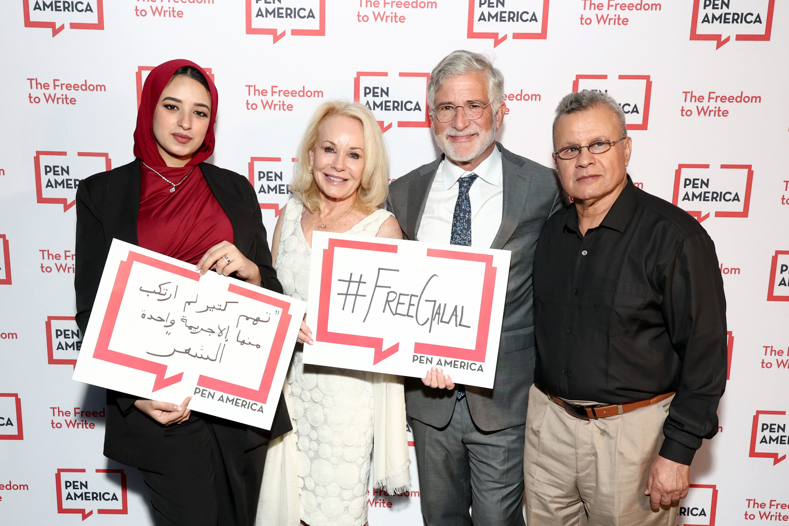 Four people pose at a PEN America event, holding signs that say #FreeJalal and messages in Arabic, standing in front of a step-and-repeat banner with the PEN America logo and The Freedom to Write slogan.
