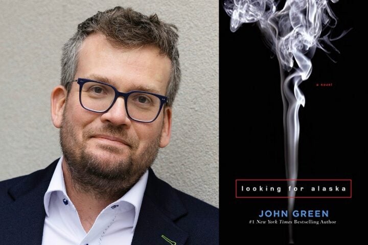 A man with glasses and a beard is shown next to the cover of the book Looking for Alaska by John Green, which features rising smoke on a black background.