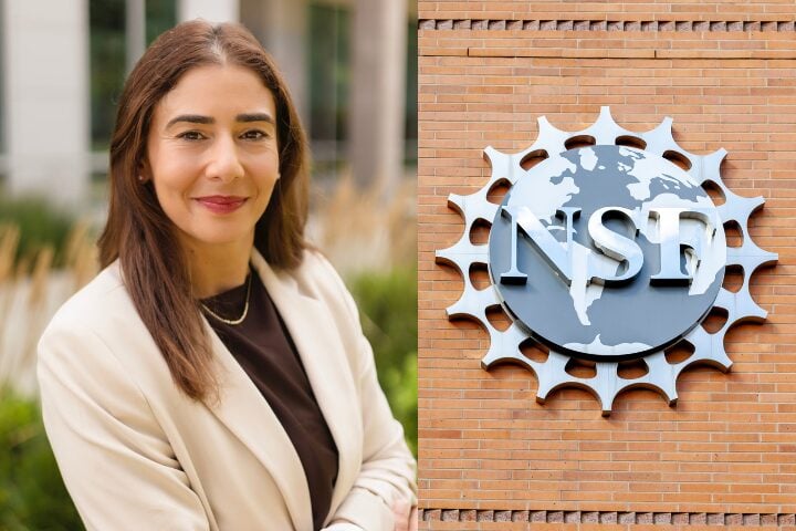 A woman with long brown hair wearing a beige blazer and black top stands outside, smiling. Next to her is a building wall with the NSF logo, featuring a globe and stylized sunburst.
