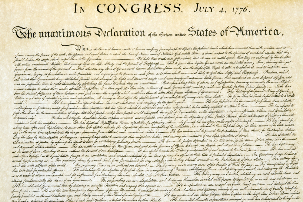 A close-up image of the original United States Declaration of Independence, dated July 4, 1776, showing elegant handwritten script and the title at the top.