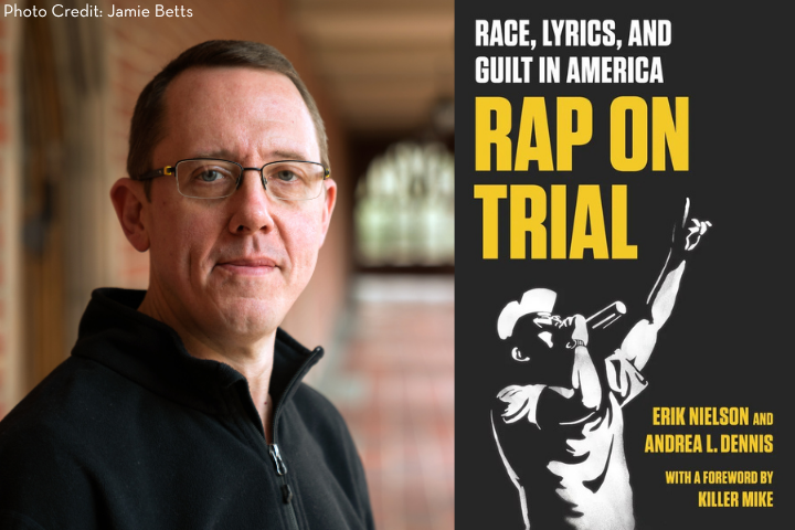A man wearing glasses and a dark shirt stands in a hallway next to the book cover for Rap on Trial: Race, Lyrics, and Guilt in America by Erik Nielson and Andrea L. Dennis, featuring an illustration of a rapper.