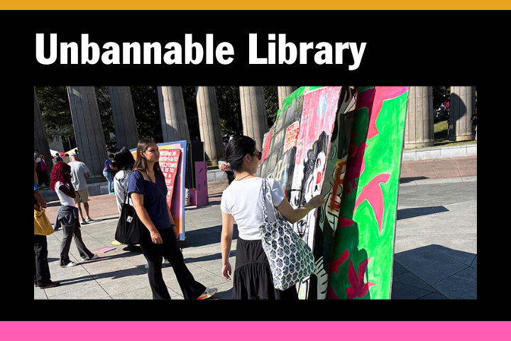 A group of people stands outside by colorful, painted book displays under the bold heading Unbannable Library on a sign. Pillars and trees are visible in the background.